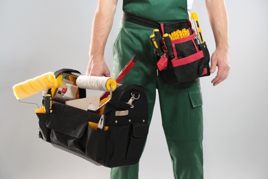 Professional construction worker with set of tools on grey background, closeup