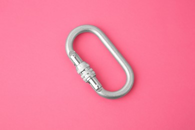 One metal carabiner on bright pink background, top view