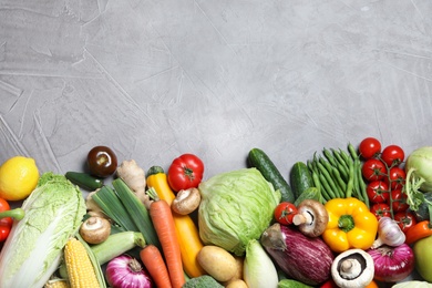 Photo of Different fresh vegetables on grey background, flat lay. Space for text