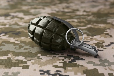 Photo of Hand grenade on digital camouflage fabric, closeup