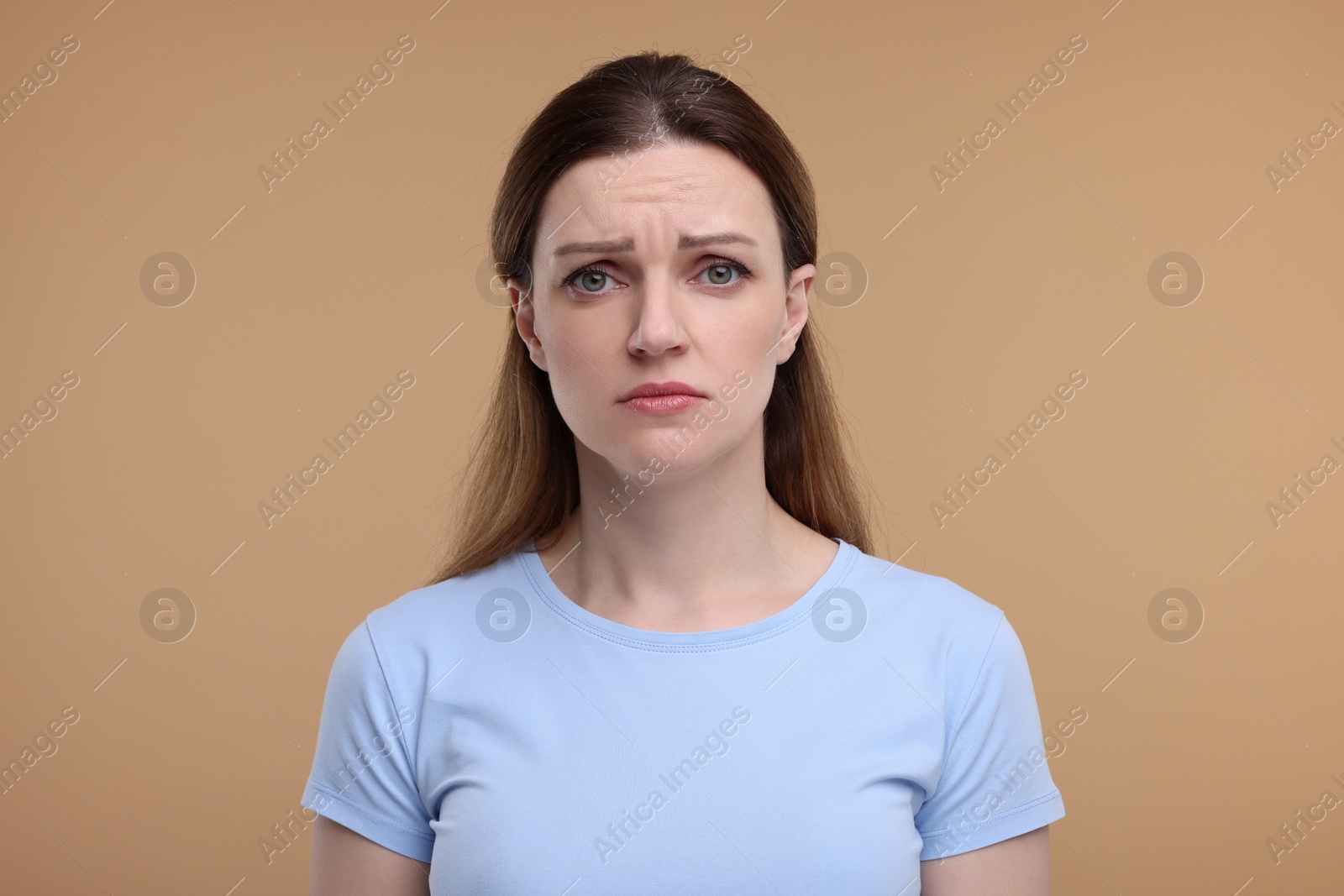 Photo of Portrait of sad woman on beige background