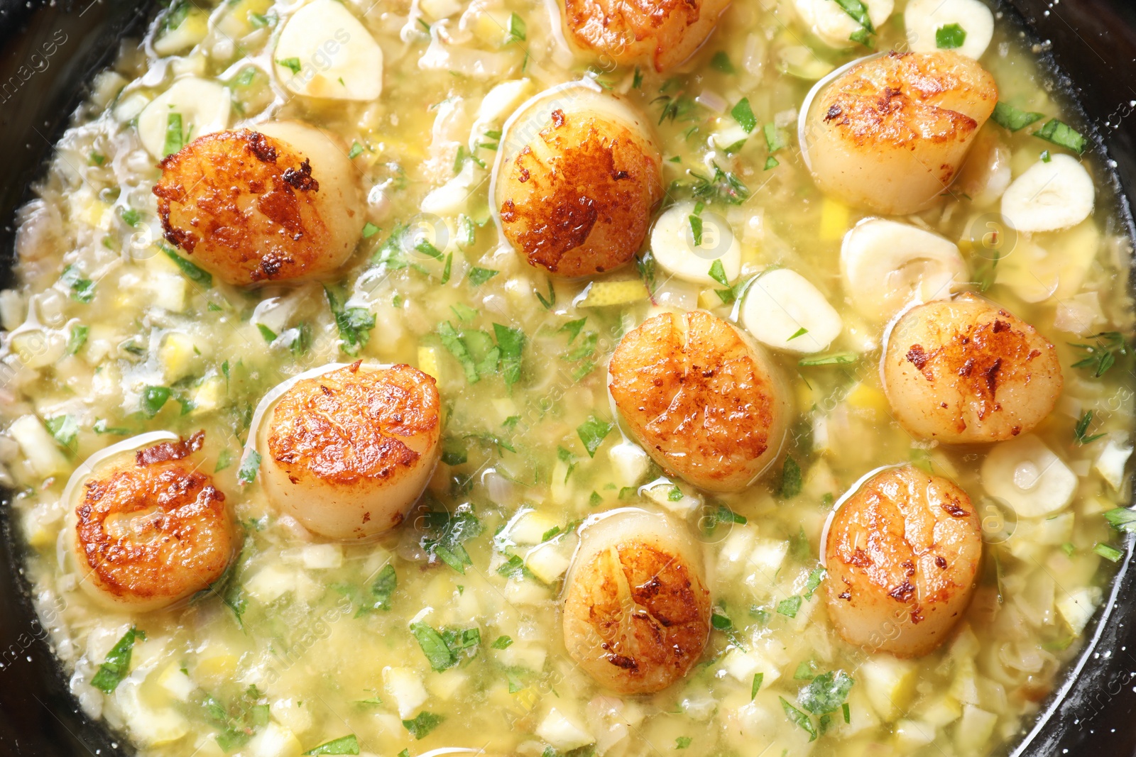 Photo of Fried scallops with sauce in dish, top view