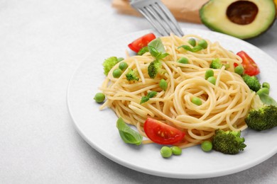 Photo of Plate of delicious pasta primavera on light gray table, closeup