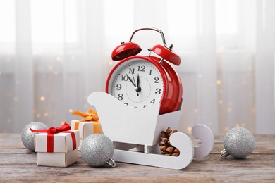 Retro alarm clock, gifts and festive decor on table. Christmas countdown