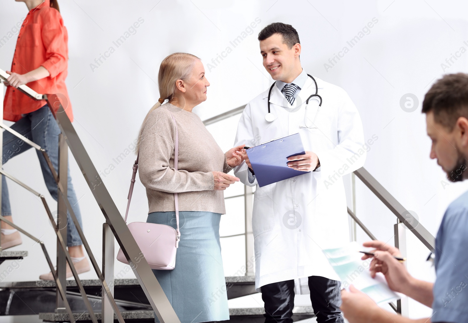 Photo of Doctor and patient discussing diagnosis on stairs in hospital