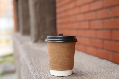 Paper cup of coffee outdoors. Takeaway drink