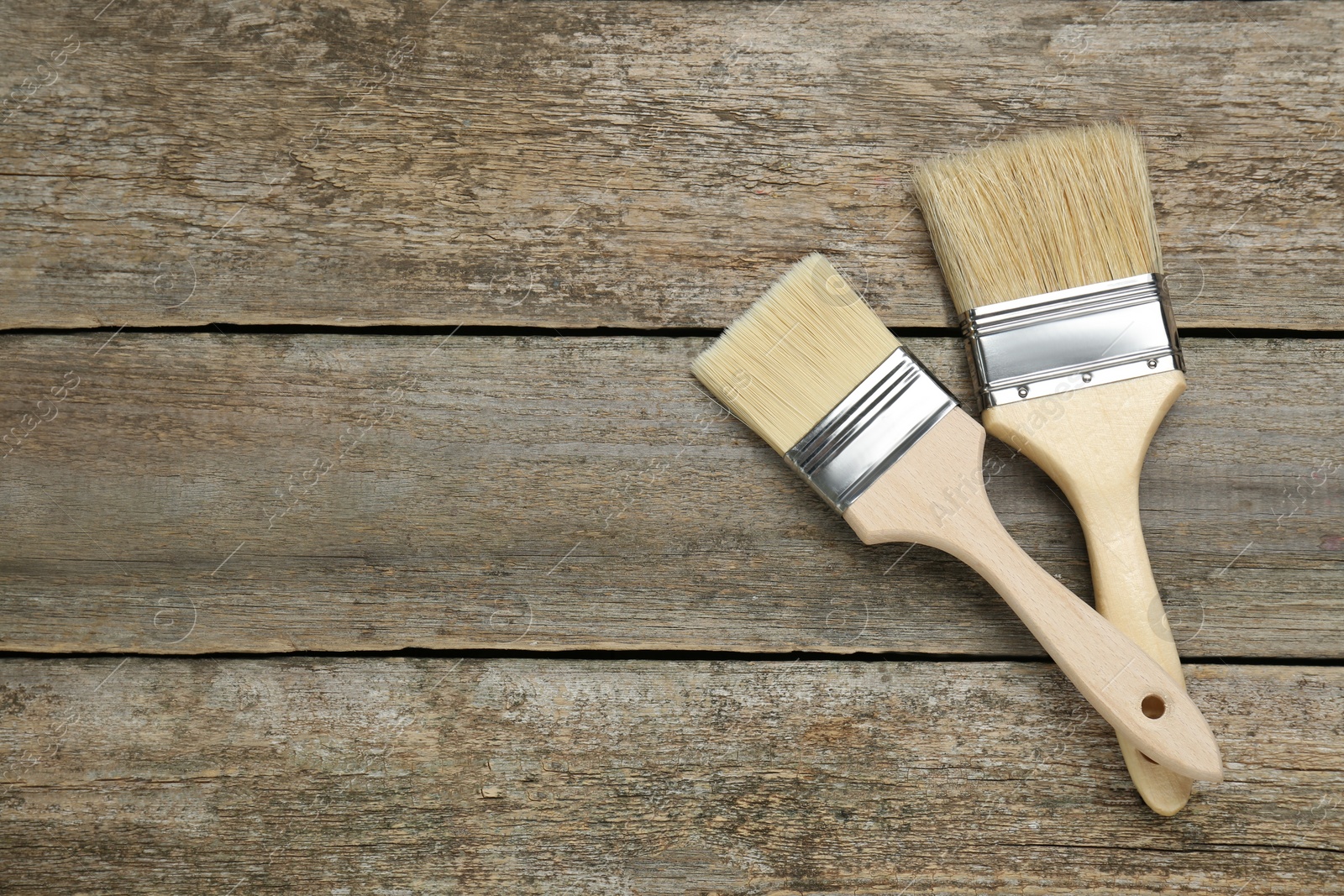 Photo of Two brushes on wooden table, flat lay. Space for text