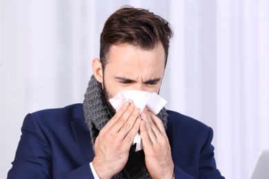 Ill businessman suffering from cough in office