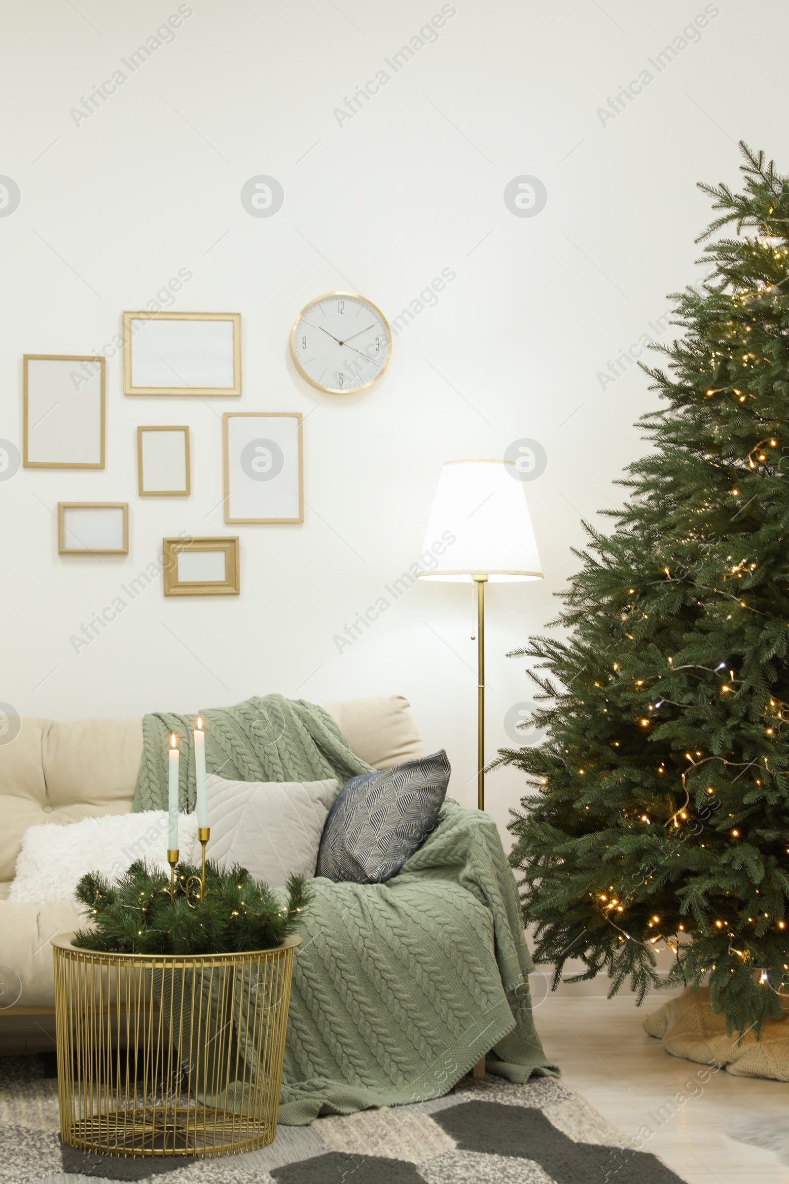 Photo of Beautiful Christmas tree with golden lights in living room