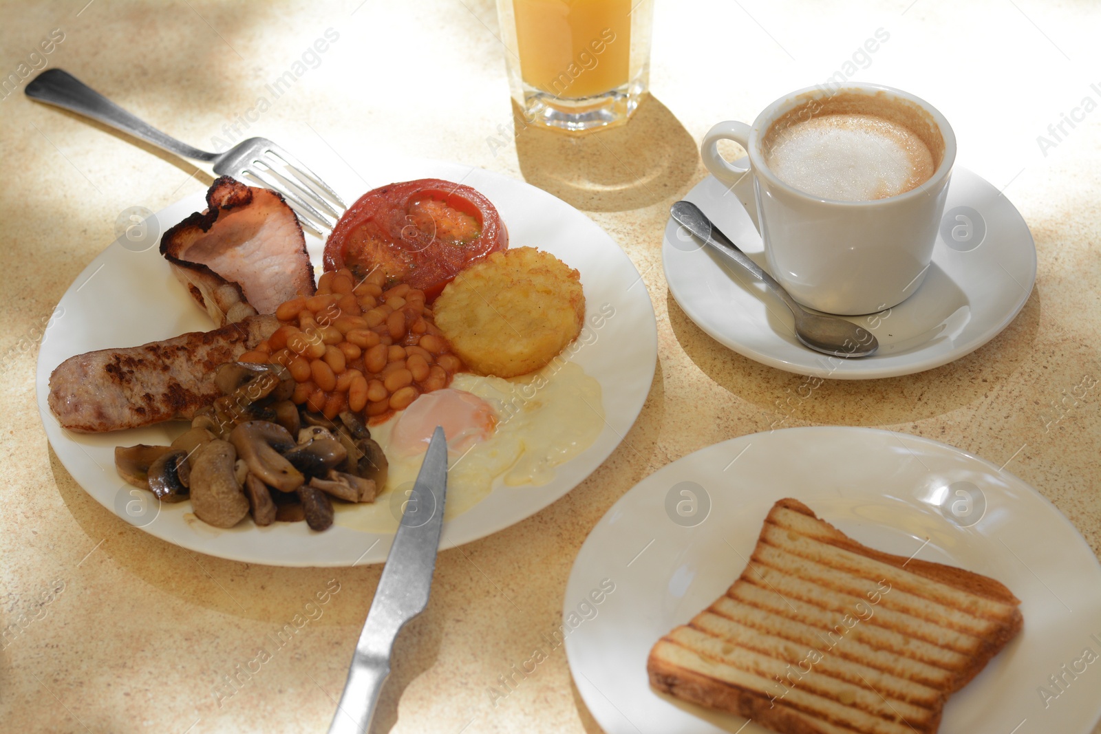 Photo of Delicious breakfast with fried meat and vegetables served on beige table