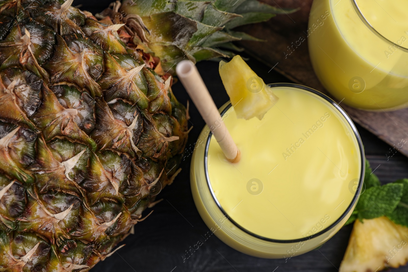 Tasty pineapple smoothie and fruit on table, above view Photo of Tasty pineapple smoothie and fruit on table, above view