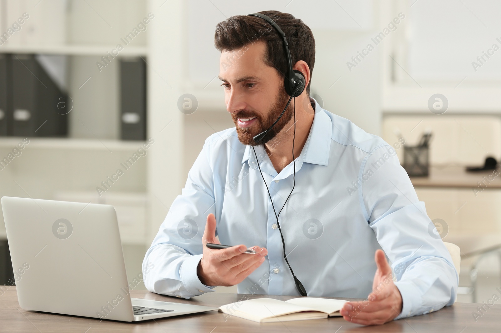 Photo of Hotline operator with headset working in office