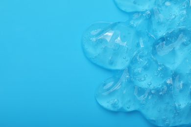 Photo of Pure transparent cosmetic gel on light blue background, top view