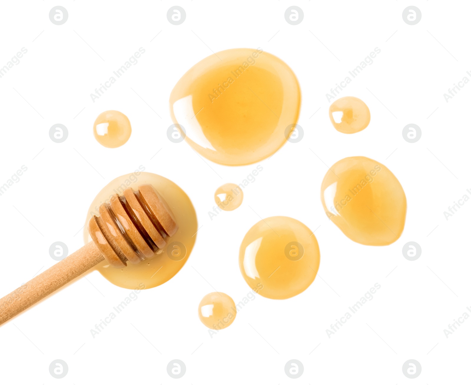 Photo of Drops of honey and dipper on white background, top view