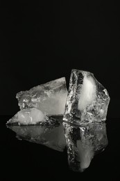 Photo of Pieces of clear ice on black mirror surface