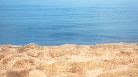 View of sea water and beach sand on sunny summer day