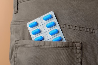 Photo of Pants with pills in pocket, closeup. Potency problem concept