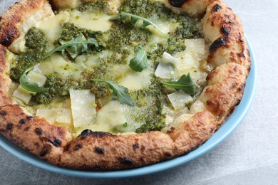 Delicious pizza with pesto, cheese and arugula on grey table, closeup