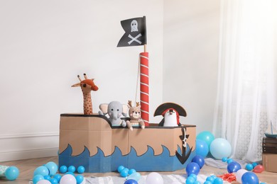 Photo of Child's room interior with pirate cardboard ship and toys