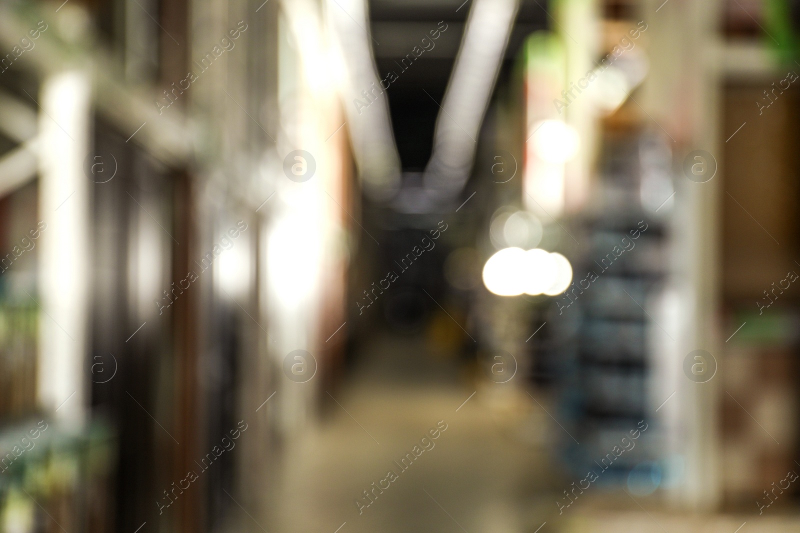 Photo of Blurred view of storage stands with different building materials in wholesale warehouse