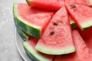 Photo of Slices of tasty ripe watermelon on light grey marble table, closeup