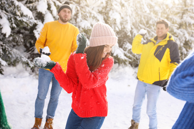 Photo of Happy friends playing snowballs outdoors. Winter vacation