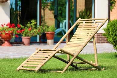 Wooden deck chair in beautiful garden on sunny day