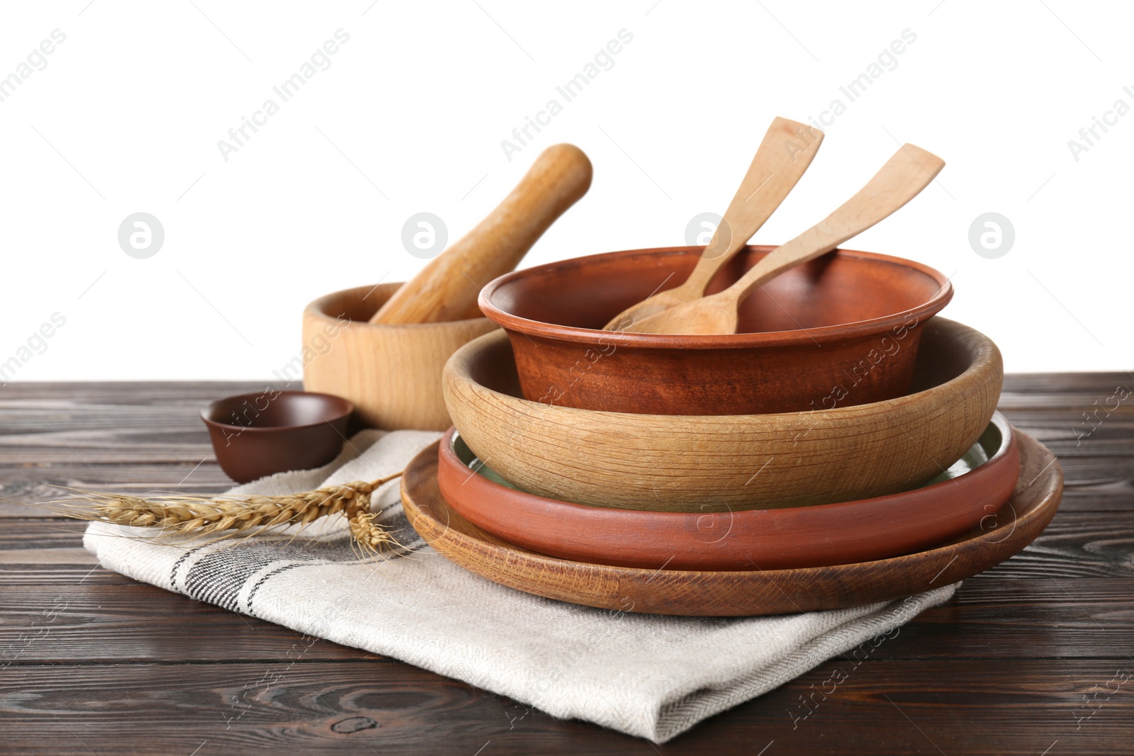 Photo of Dishware and napkin on wooden table against white background