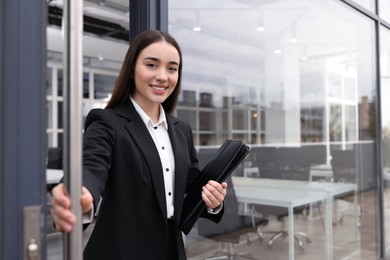 Photo of Real estate agent with leather portfolio inviting inside. Space for text