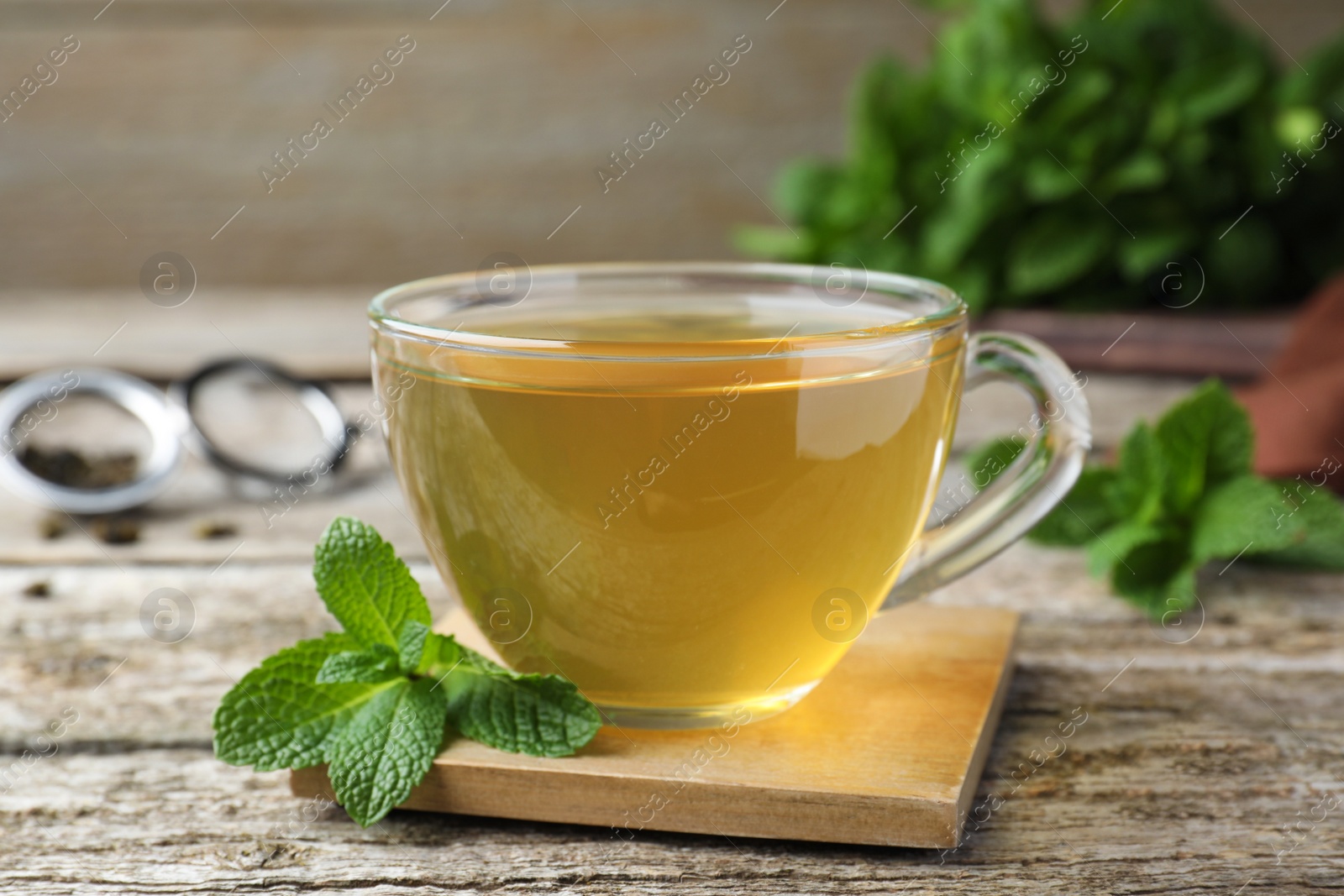 Photo of Cup of hot aromatic mint tea on wooden table