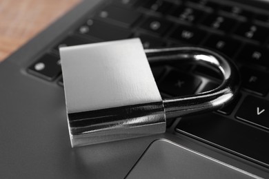 Photo of Cyber security. Laptop with padlock on table, closeup