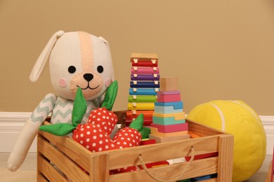 Set of different cute toys near beige wall