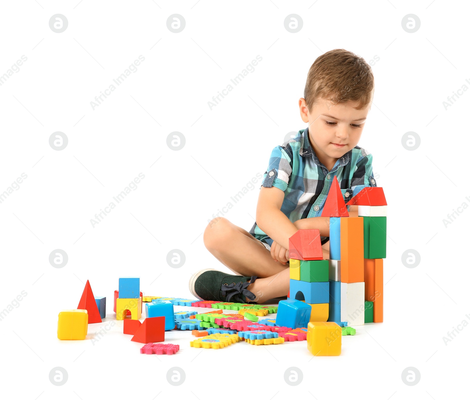 Photo of Little child playing with blocks on white background. Indoor recreation