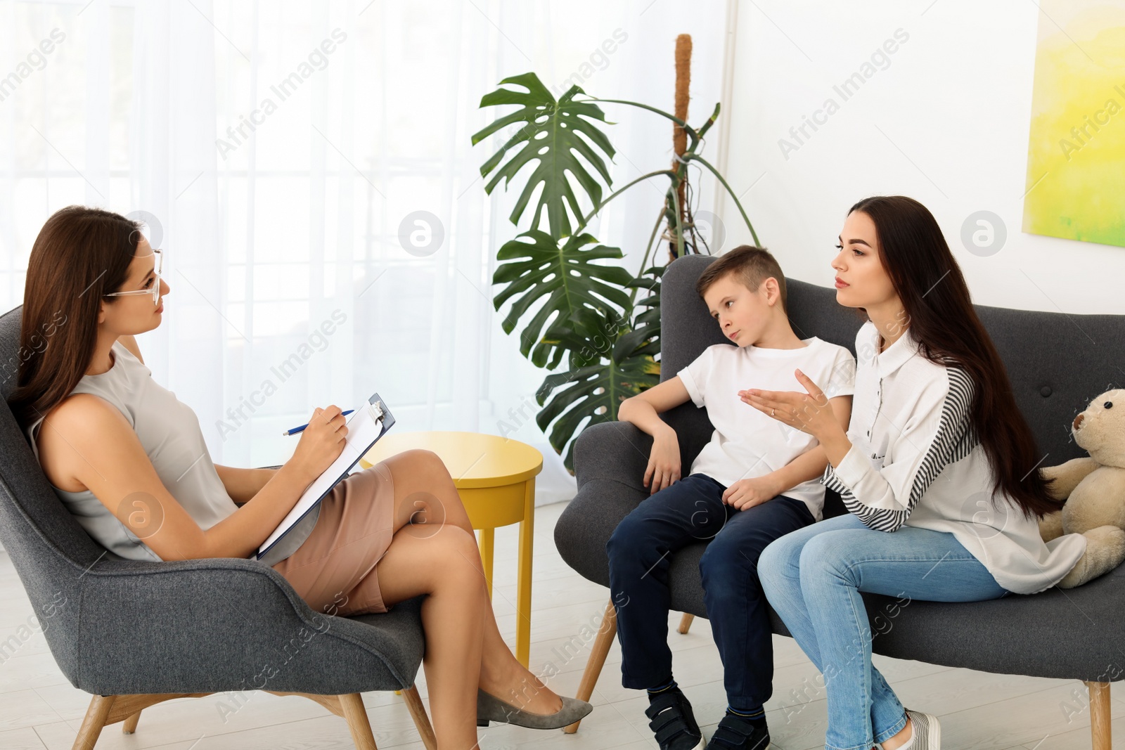 Photo of Young woman and her son having appointment with child psychologist in office