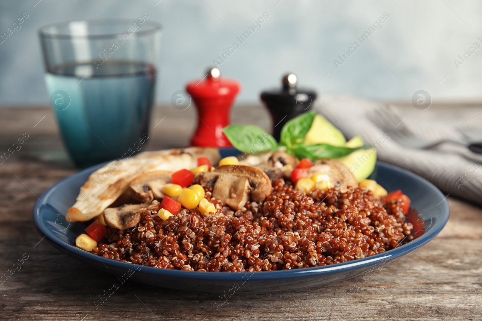 Photo of Plate with quinoa and garnish on table, closeup