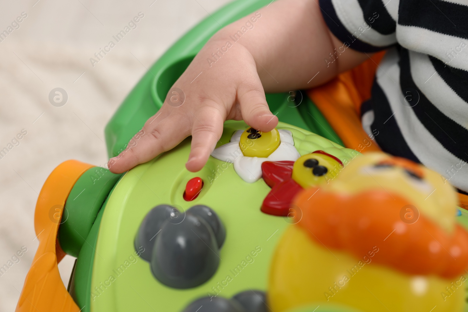 Photo of Little baby playing with toy walker, closeup