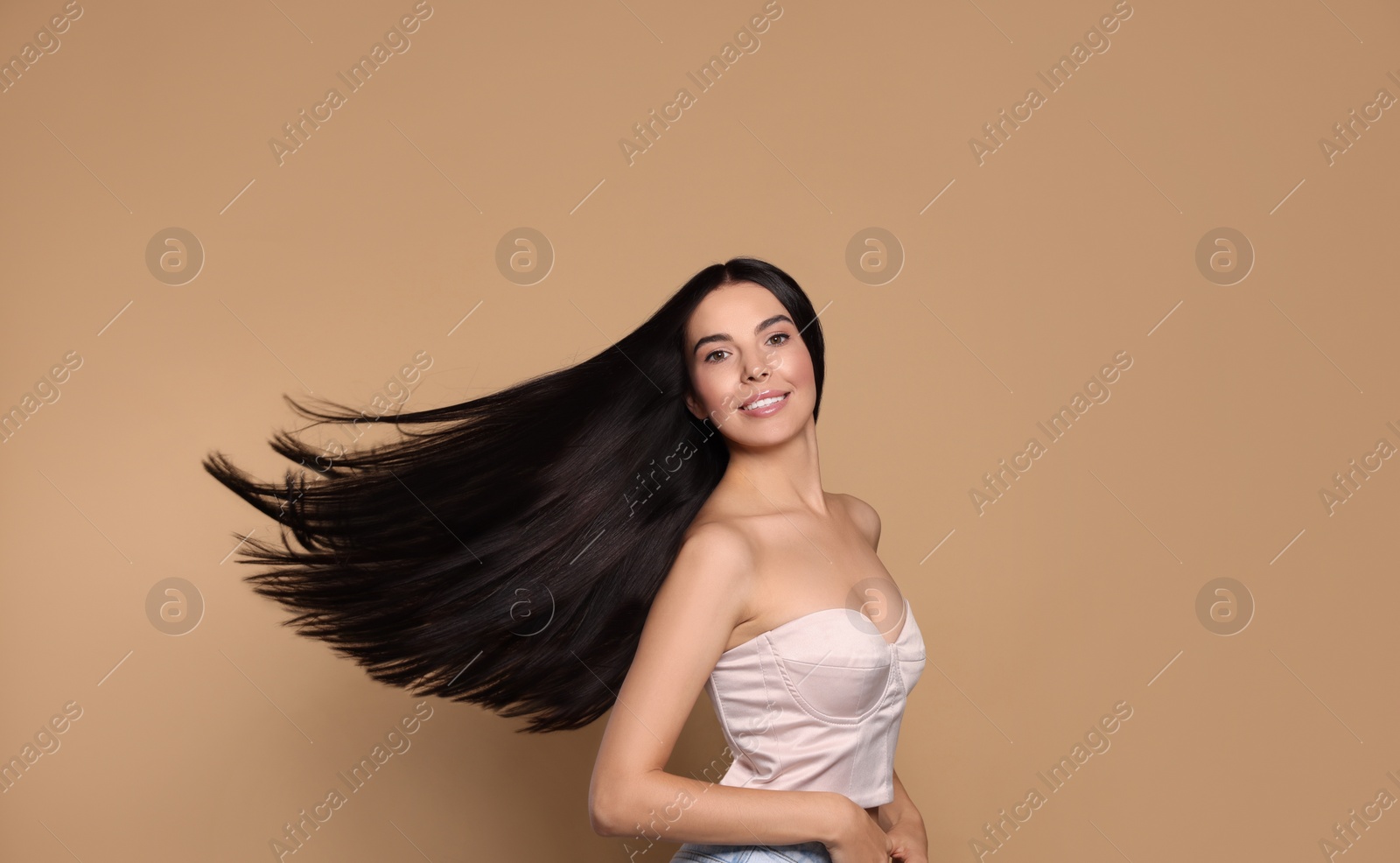 Photo of Portrait of beautiful young woman with healthy strong hair on beige background