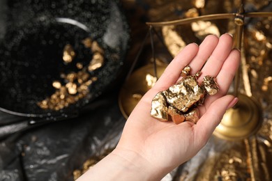 Photo of Woman with gold nuggets, closeup. Space for text