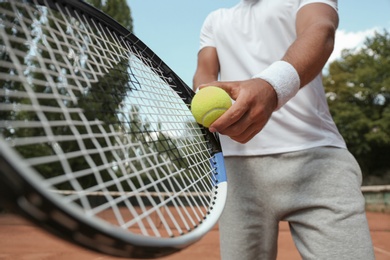 Photo of Sportsman preparing to serve tennis ball at court, closeup