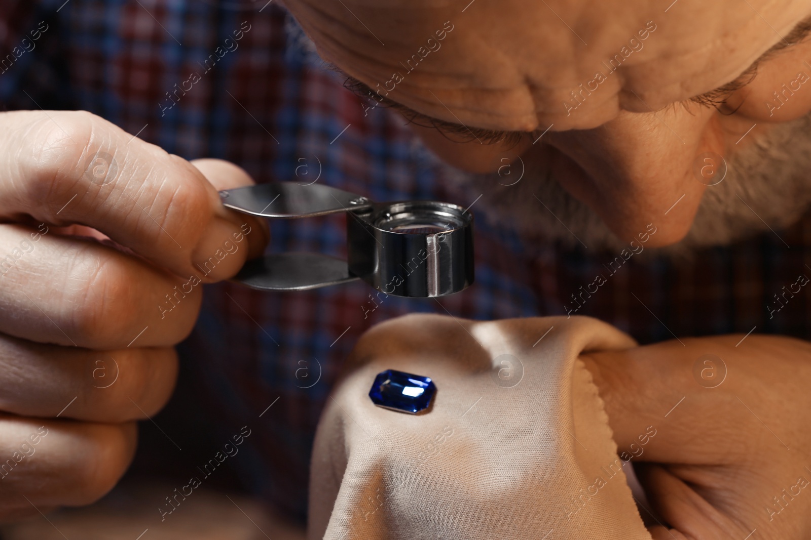 Photo of Professional jeweler working with gemstone, closeup view