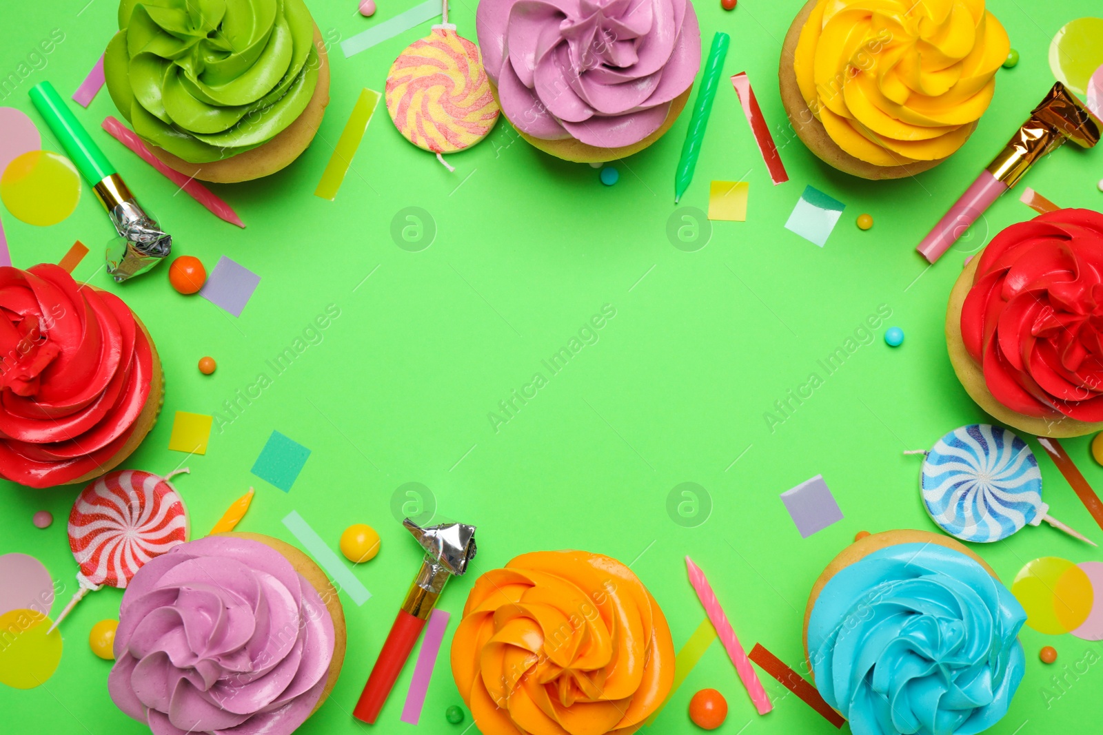 Photo of Flat lay composition with colorful birthday cupcakes on green background. Space for text