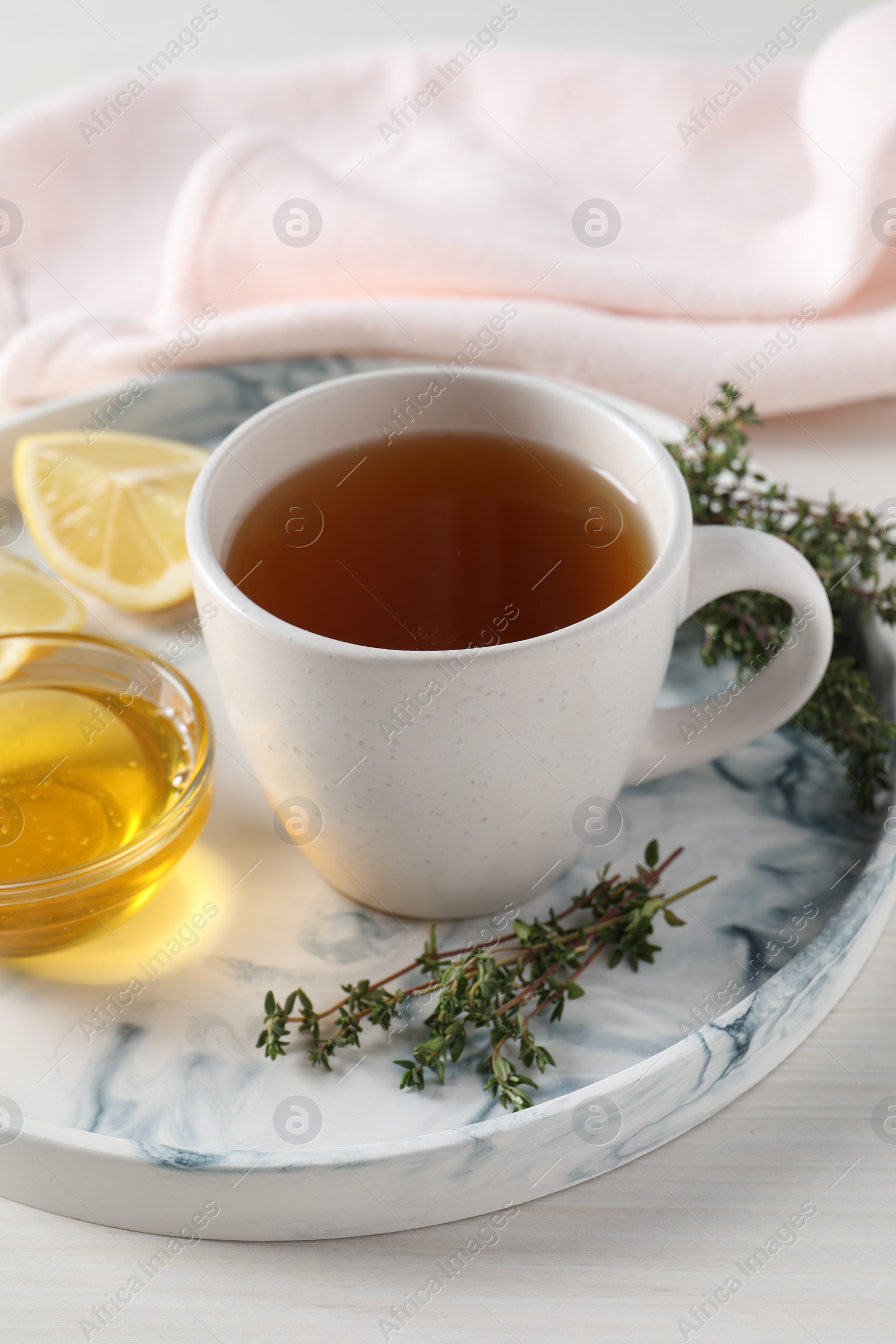 Photo of Aromatic herbal tea with thyme, honey and lemon on white wooden table