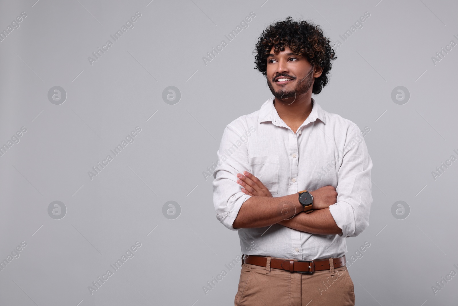 Photo of Handsome smiling man on light grey background, space for text