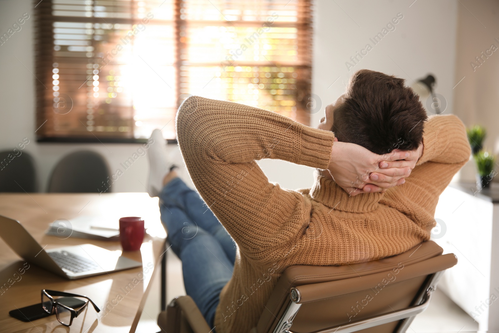 Photo of Young man relaxing at desk in office