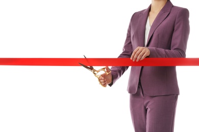 Woman in office suit cutting red ribbon isolated on white, closeup