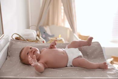 Cute little baby on changing table in room