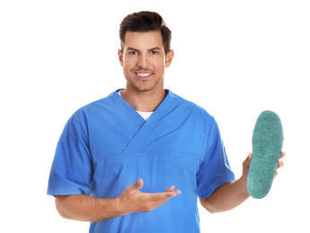 Male orthopedist showing insole on white background