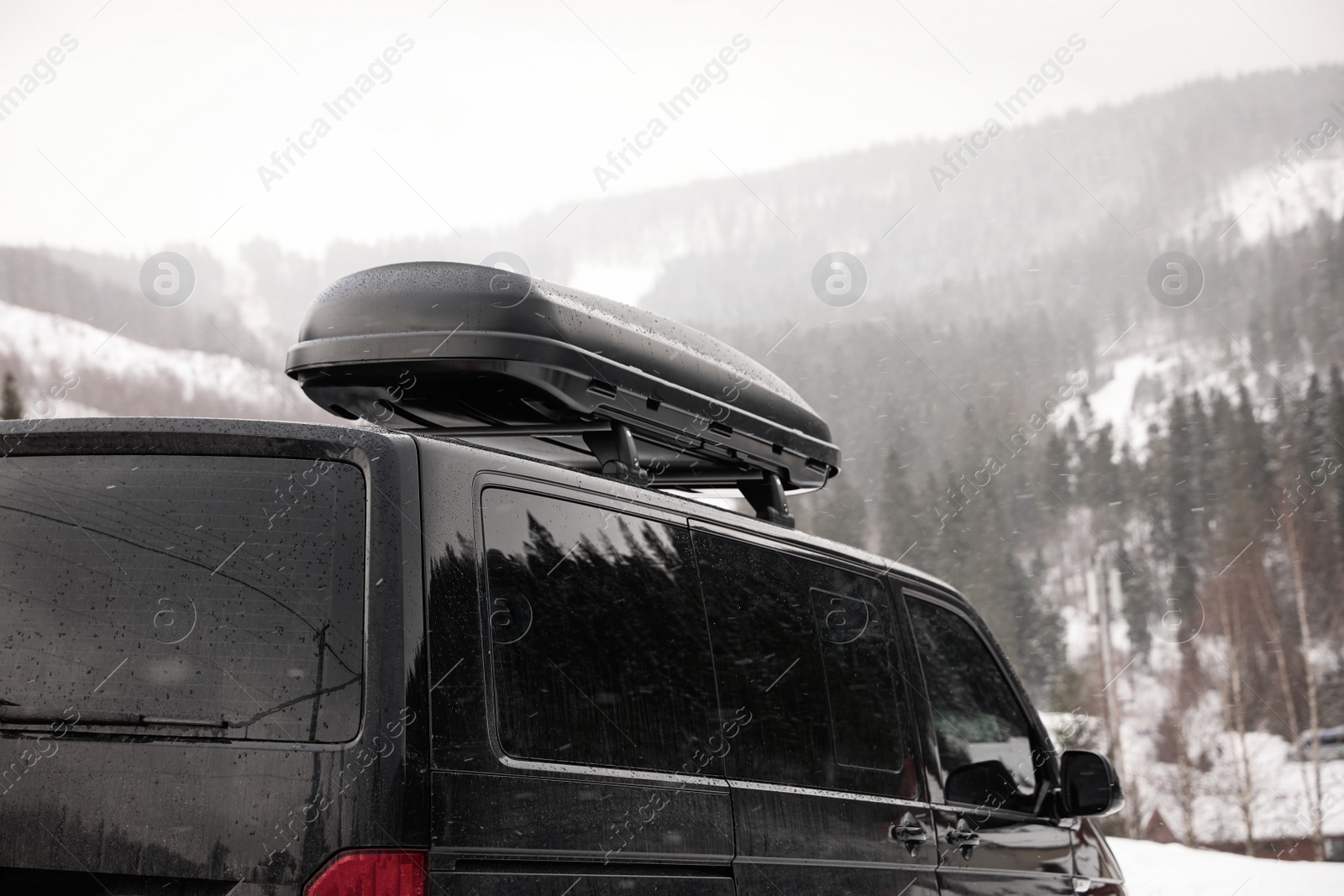 Photo of Black car with roof rack outdoors. Winter vacation