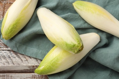 Photo of Fresh raw Belgian endives (chicory) on wooden table, top view