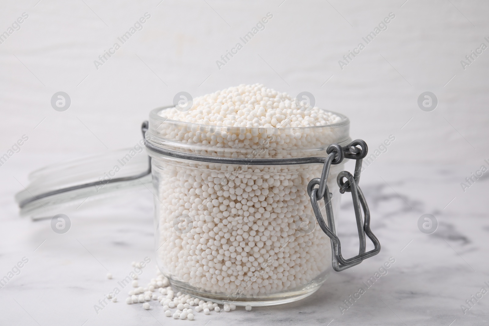 Photo of Tapioca pearls in jar on white marble table